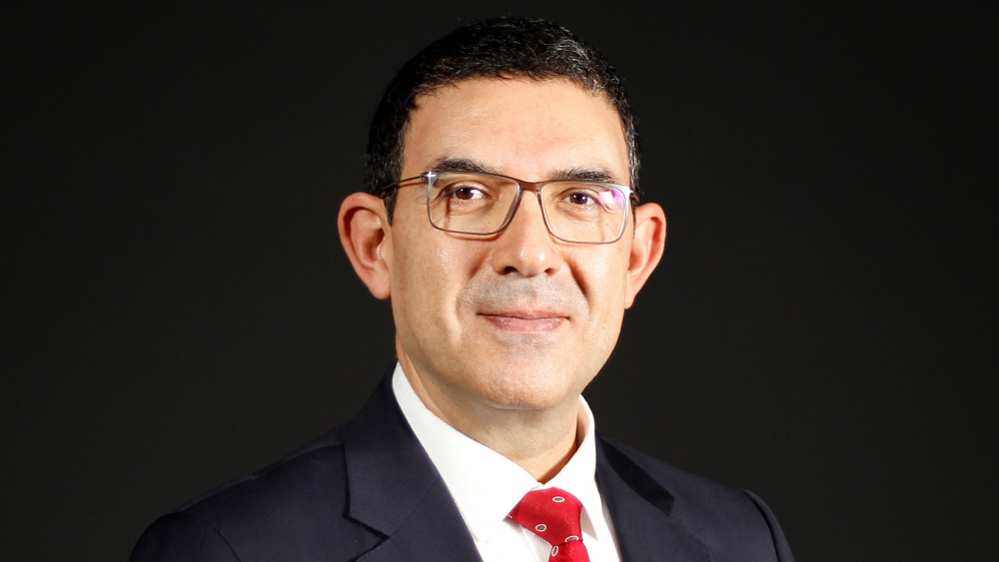 Prof Dr Atakan Yalçın, wearing spectacles and a black suit with red tie