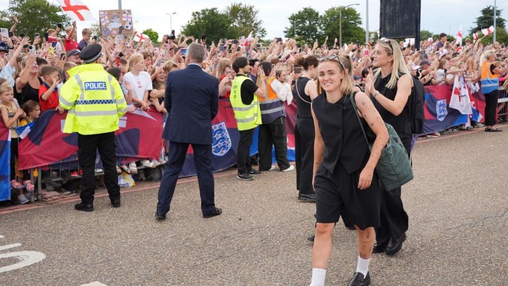 England's Georgia Stanway greets fans after arriving at London Southend Airport. England defended their European Championship crown as they beat Spain on penalties in the final of Euro 2025.