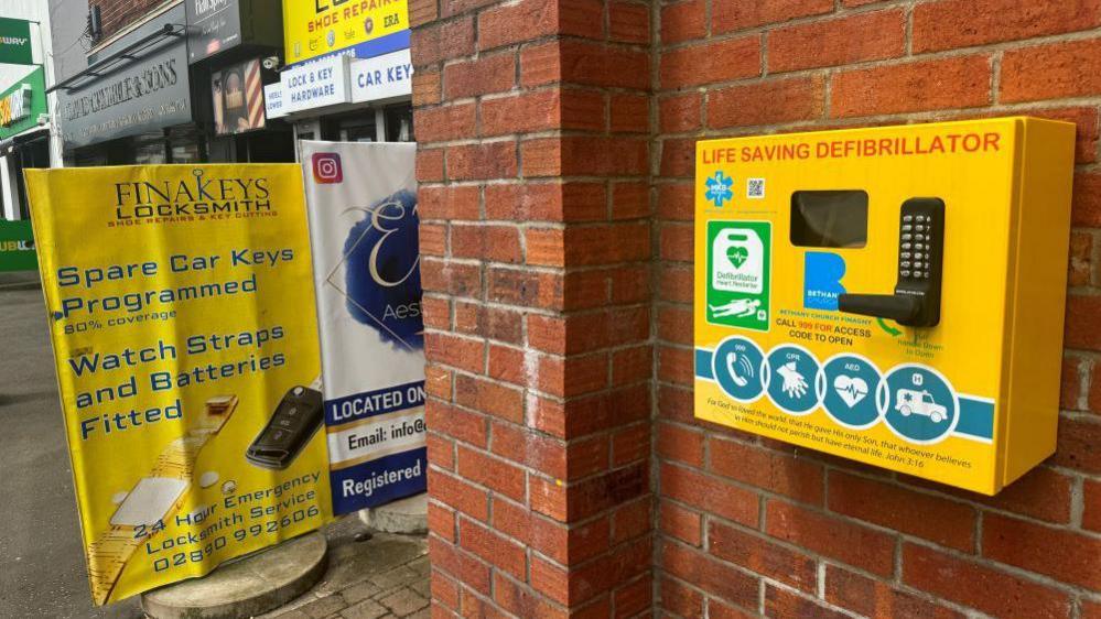 The defibrillator on a red brick wall at Bethany Church