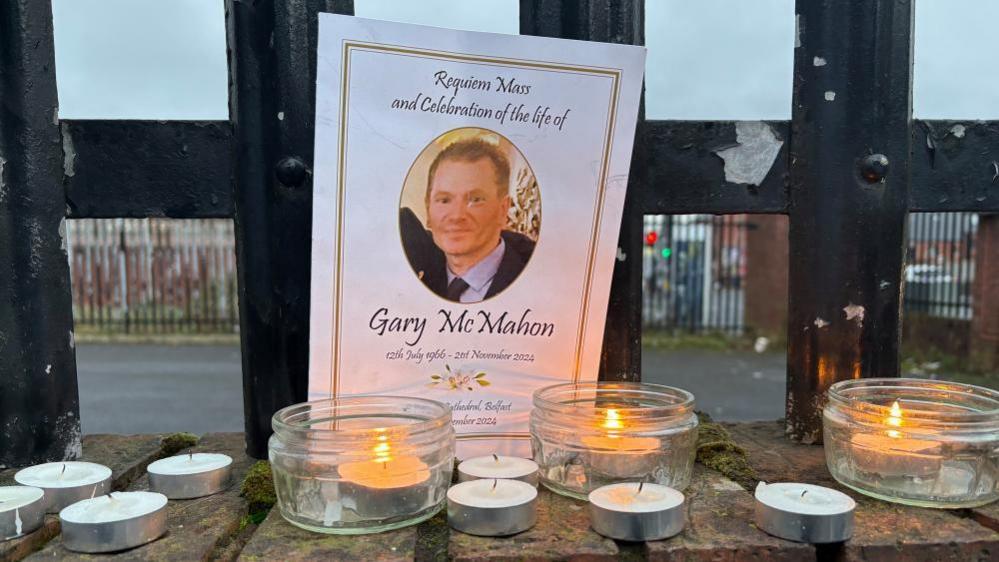 Candles have been lit and are placed in front of a picture of Gary.