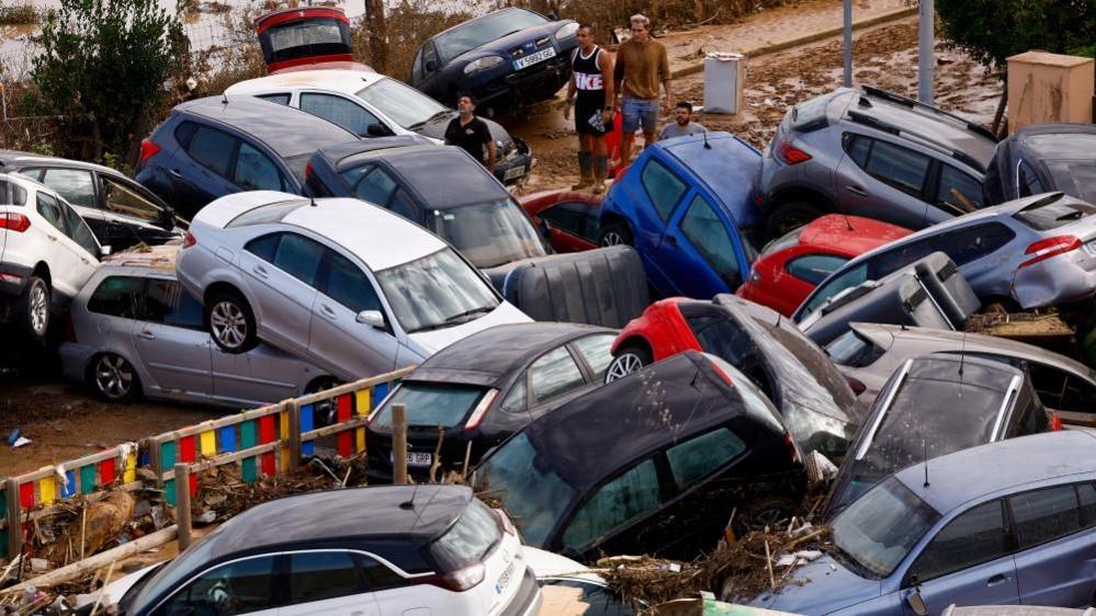 People stand next to stranded cars, following floods in Valencia, Spain, October 31, 2024.