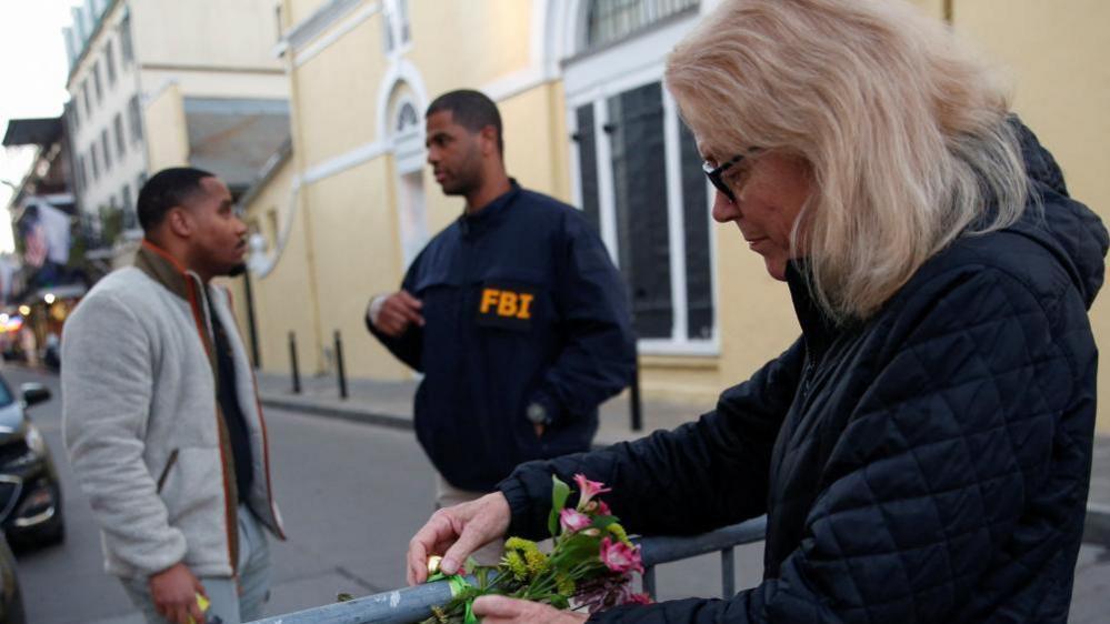 Woman leaving flowers near the site of the attack in New Orleans. 