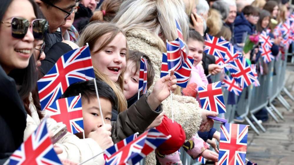 Crowds of people waving flags