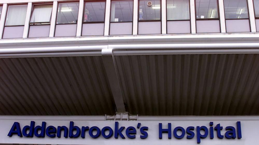 A sign saying "Addenbrooke's Hospital" at the entrance to the site, in big blue individual letters.