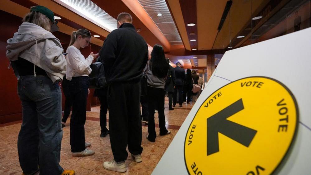 People wait in line to register to vote at a polling station for Canada's federal election, in Toronto, Ontario