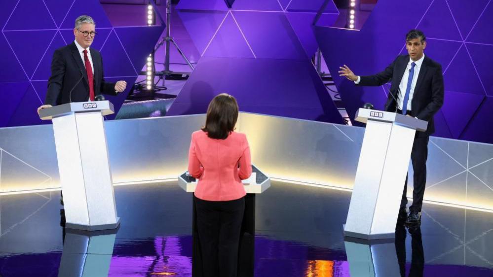 Keir Starmer and Rishi Sunak wearing suits stand at two podiums during the BBC election debate