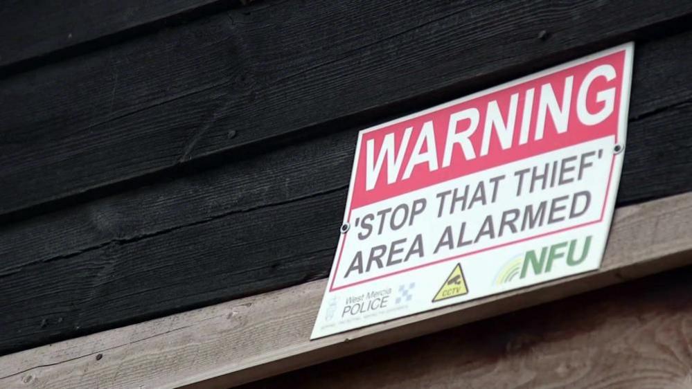 A warning sign to thieves tells that this farm is alarmed.