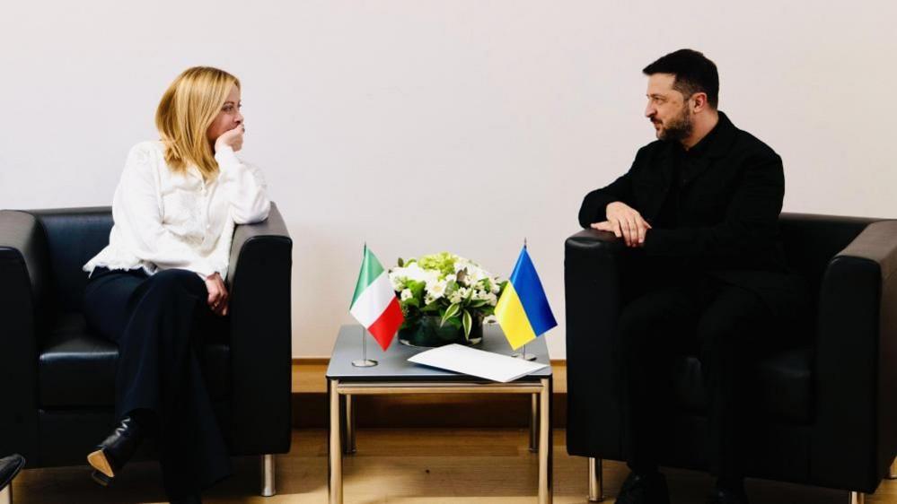 Volodymyr Zelensky and Italian leader Giorgia Meloni turn towards each other as they sit down during a meeting at the Brussels summit on Thursday.