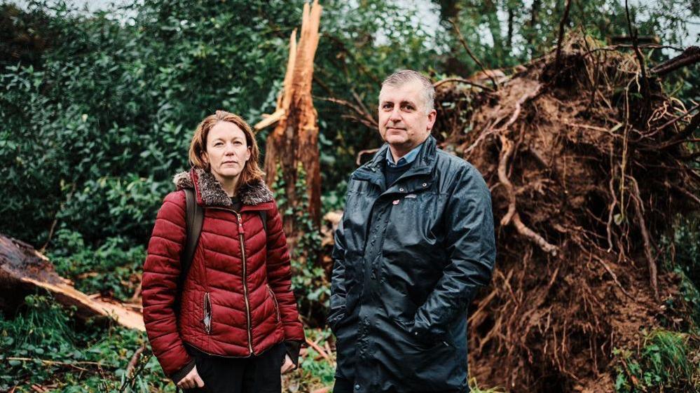 Alex Morel and Helier Smith standing in front of an uprooted tree