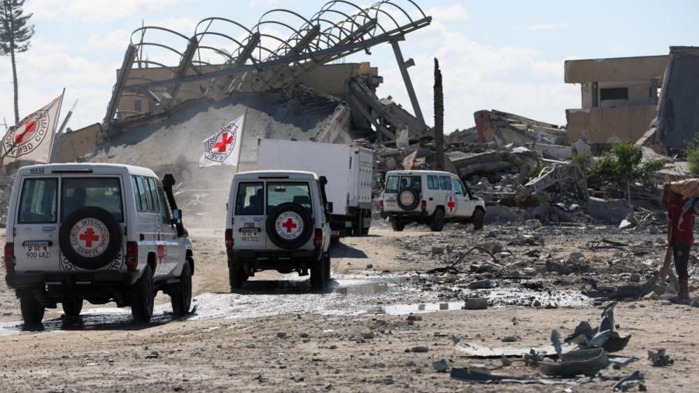 Red Cross vehicles escort a truck transporting the bodies of Palestinians who had been held in Israel during the war