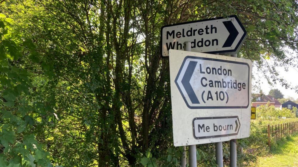 Road sign pointing to Meldreth, Cambridge and "Me bourn"