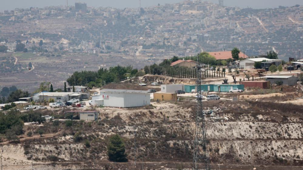 A wide view of Havat Gilad outpost, a cluster of prefabricated buildings perched on a hilltop in the occupied West Bank