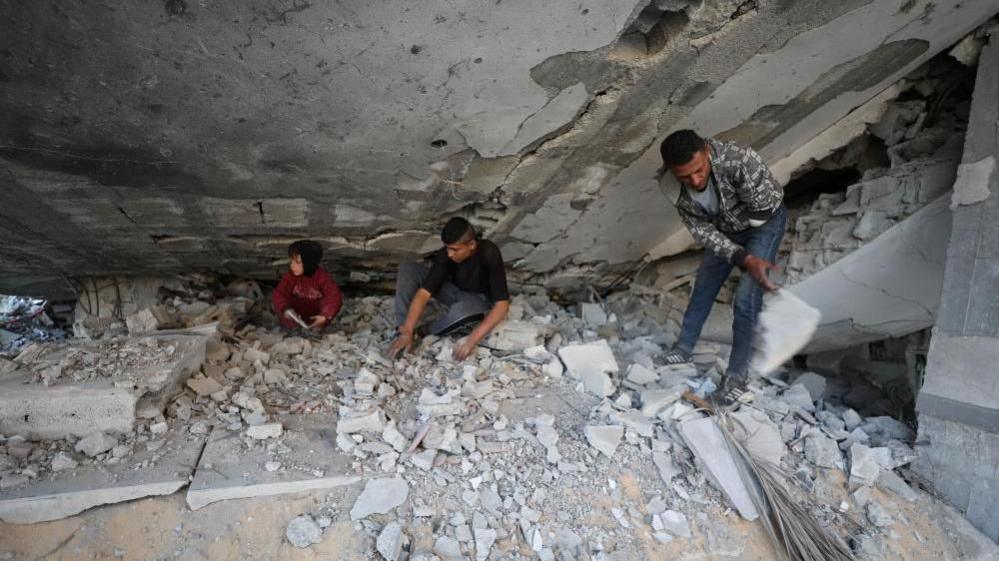 A family search for belongings amongst the rubble of their destroyed house, after returning to it amid a ceasefire between Israel and Hamas, in Jabalia, northern Gaza Strip, January 30, 2025. 