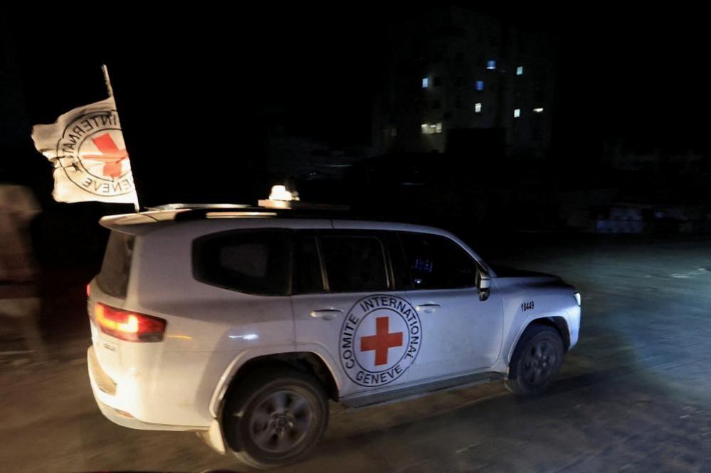 A white Red Cross vehicle with a cross emblem on its side and a flag waving from its roof, pictured on 27 October, 2025 against a night-time backdrop.