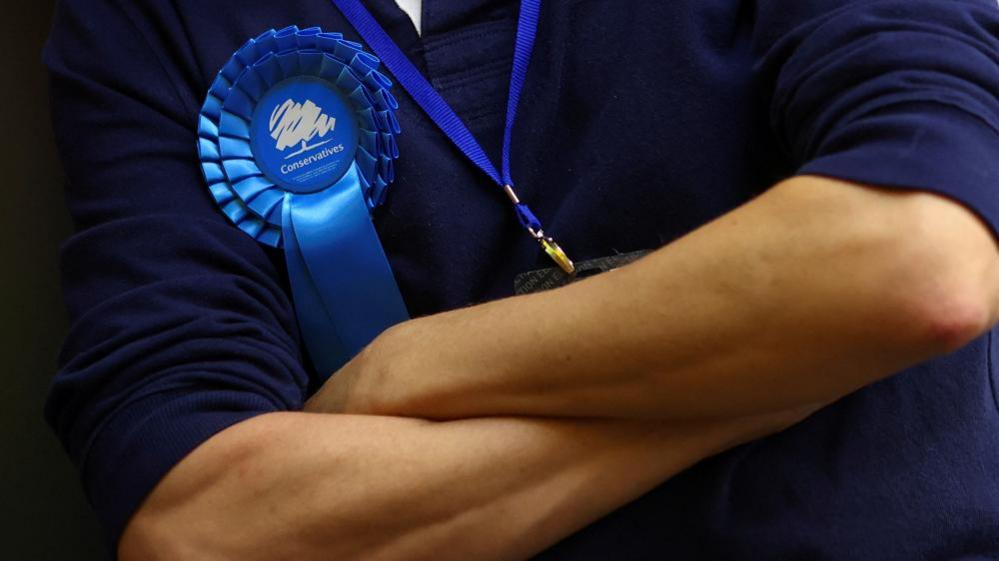 Man wearing a Conservative rosette