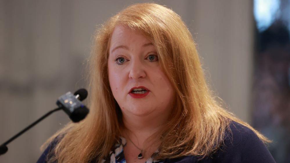 Naomi Long speaking into microphone 