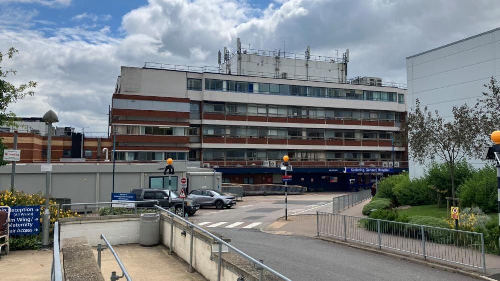 Four storey glass and brick hospital building with road 