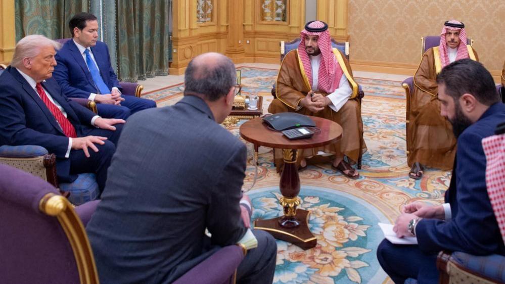 Donald Trump, Marco Rubio, Mohammad bin Salman and Ahmed al-Sharaa sit in a circle of armchairs.