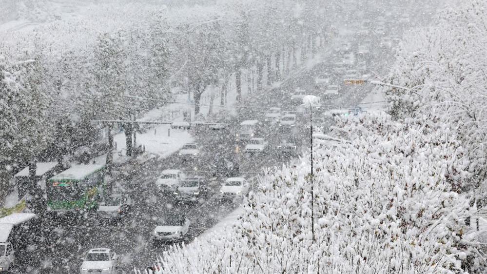 Cars move slowly on a snow-covered road in southern Seoul, South Korea.