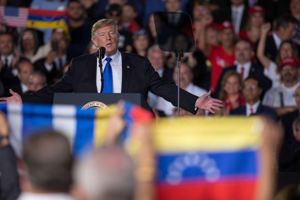 Trump habla en 2019 ante miembros de la comunidad de Venezuela en Miami, con la bandera de este país delante y detrás suyo