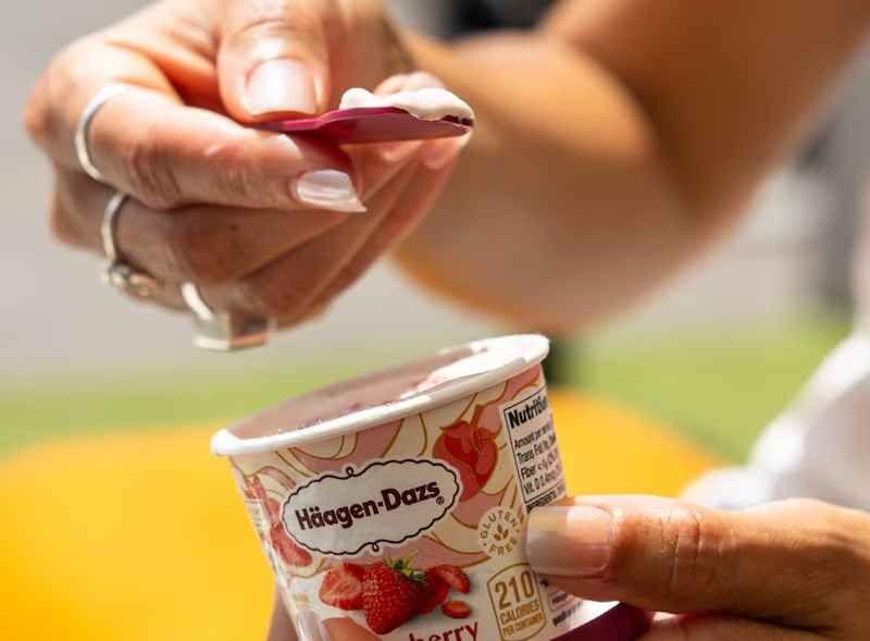 sorvete de morango pequeno da marca em mãos femininas