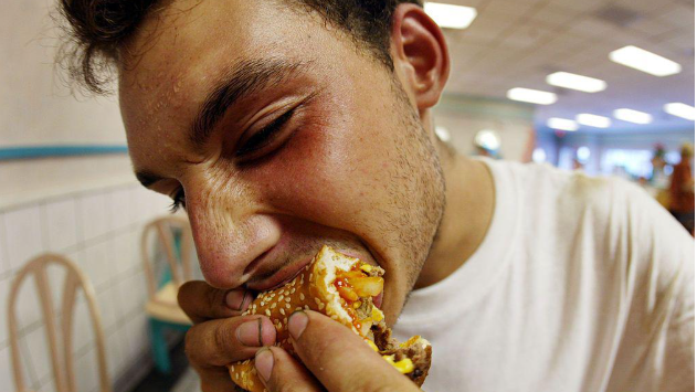 شاب يقضم شطيرة.