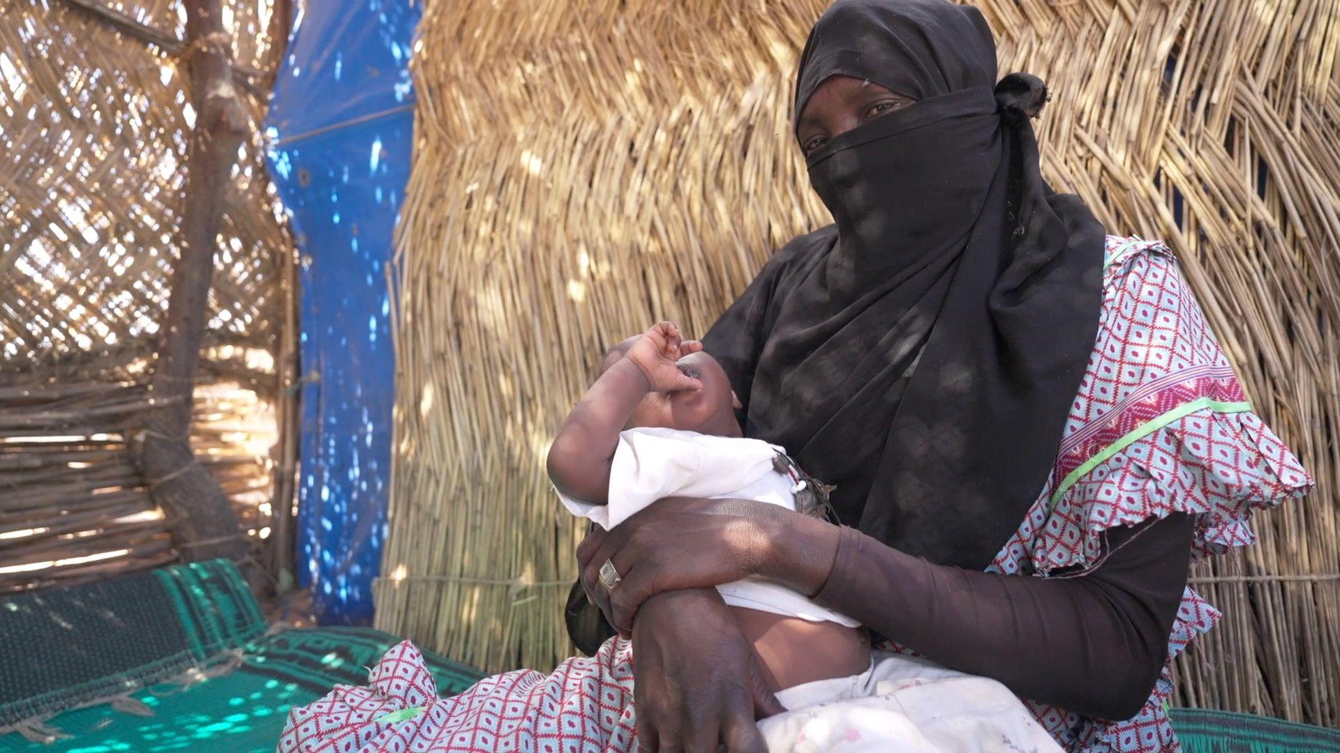 زينب تحمل ابنتها مريم بين ذراعيها