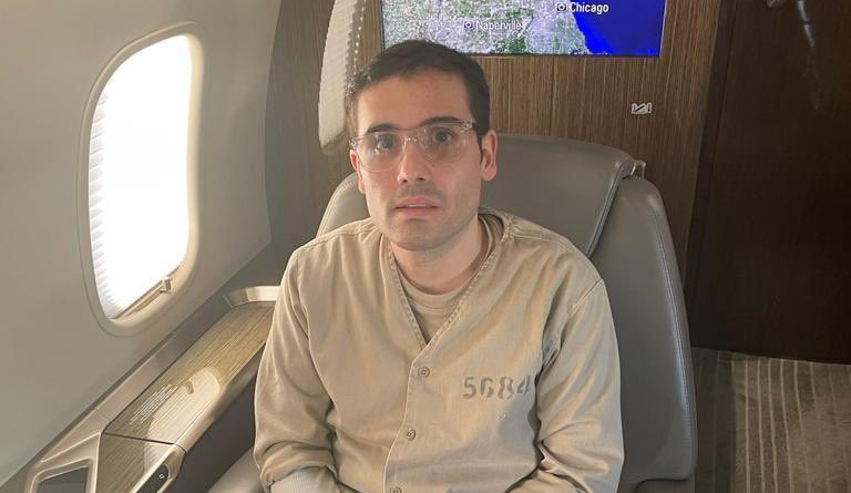 Ovidio Guzmán viste un traje de preso sentado a bordo de un avion