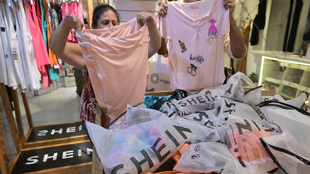 Dos mujeres observan prendas importadas de la marca china Shein en una tienda en Buenos Aires, el 6 de febrero de 2026. 