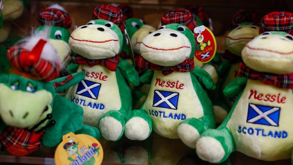 Bonecos de pelúcia do Monstro do Lago Ness, com a bandeira da Escócia