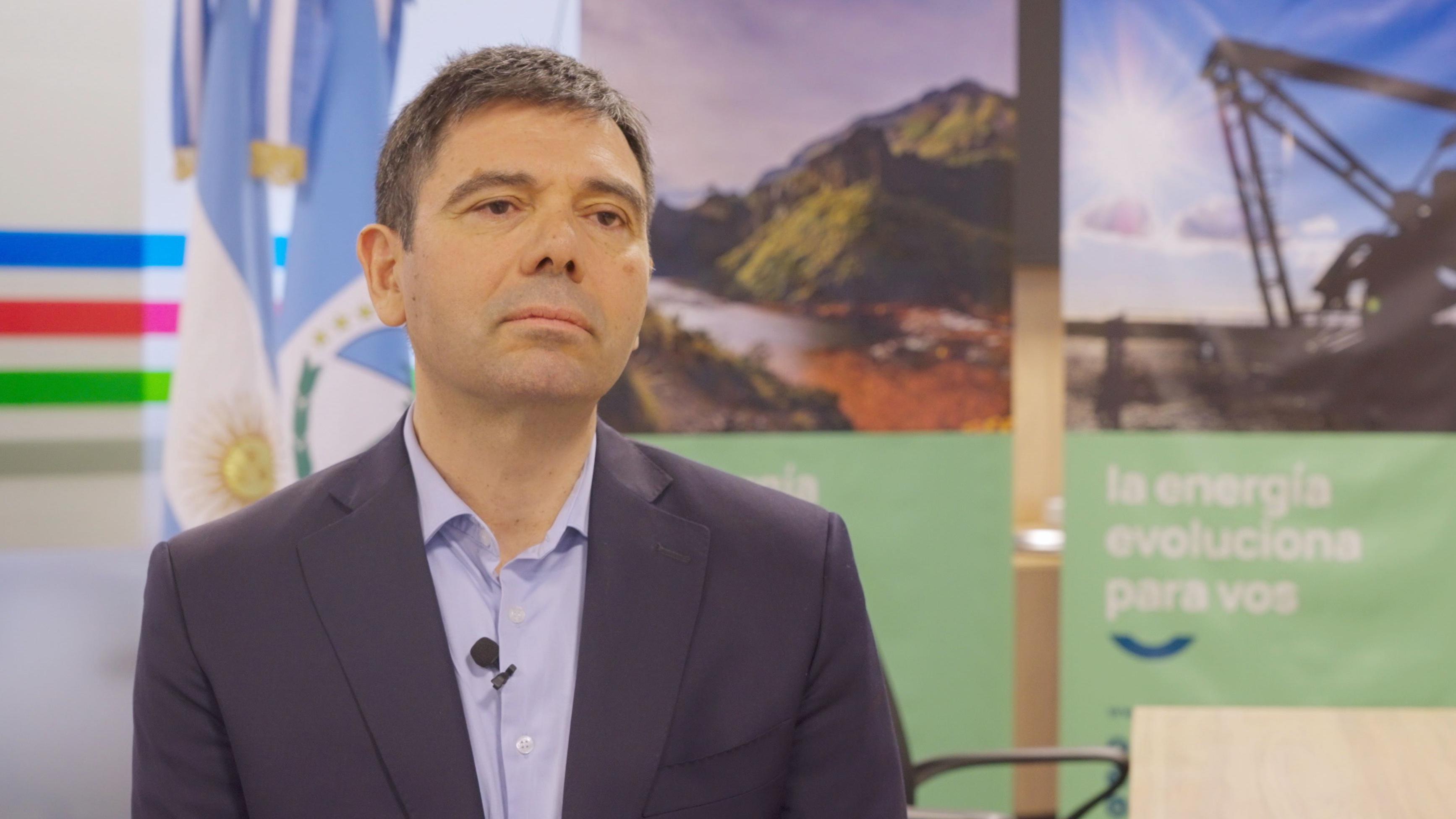 Un hombre de saco y camisa con un micrófono