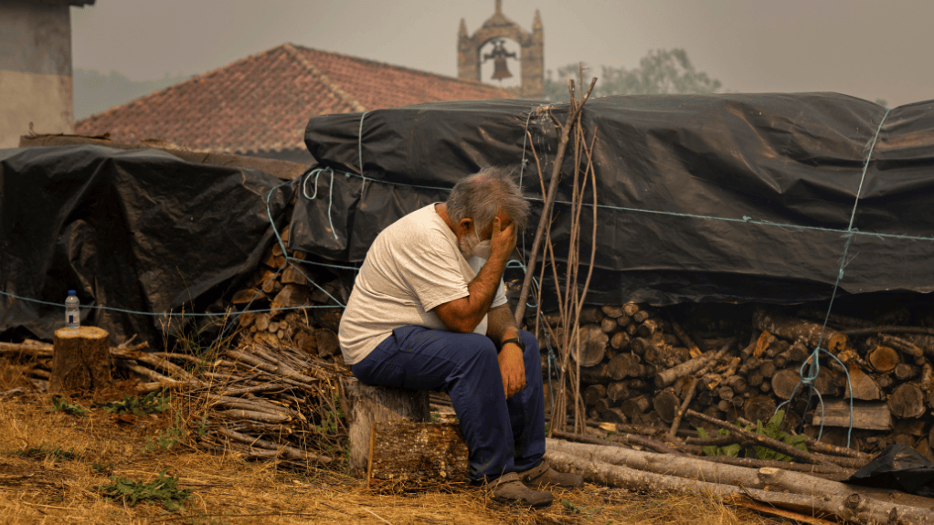 Homem sentado com as mãos da cabeça, em uma das regiões afetadas pelos incêndios na Espanha.