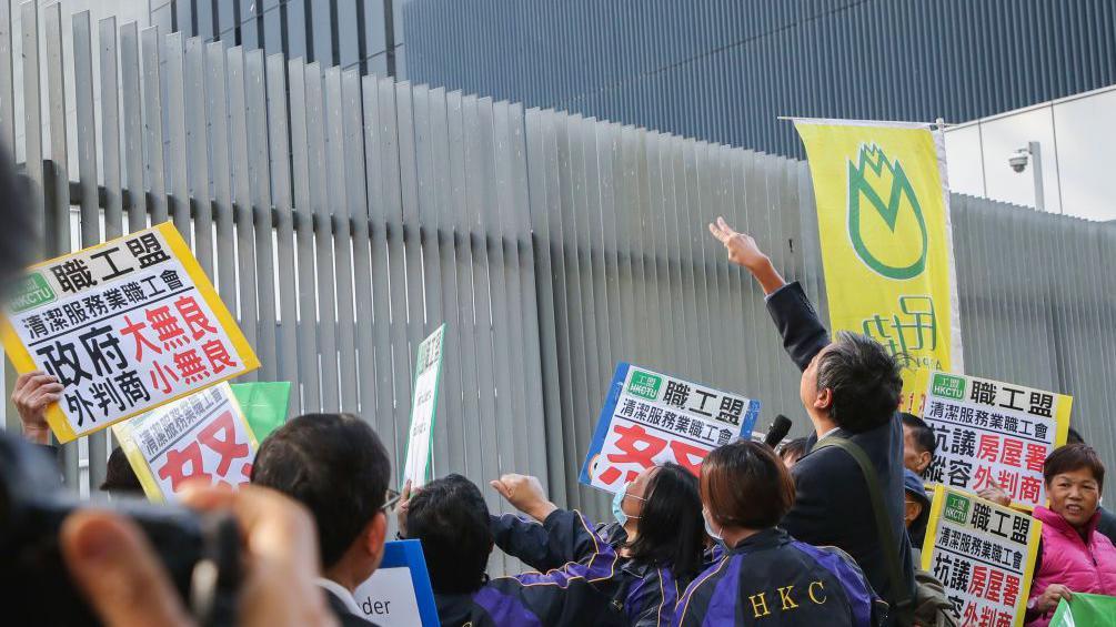 2017年12月，香港職工盟、民協以及海麗邨清潔工人在添馬艦政府總部外抗議。
