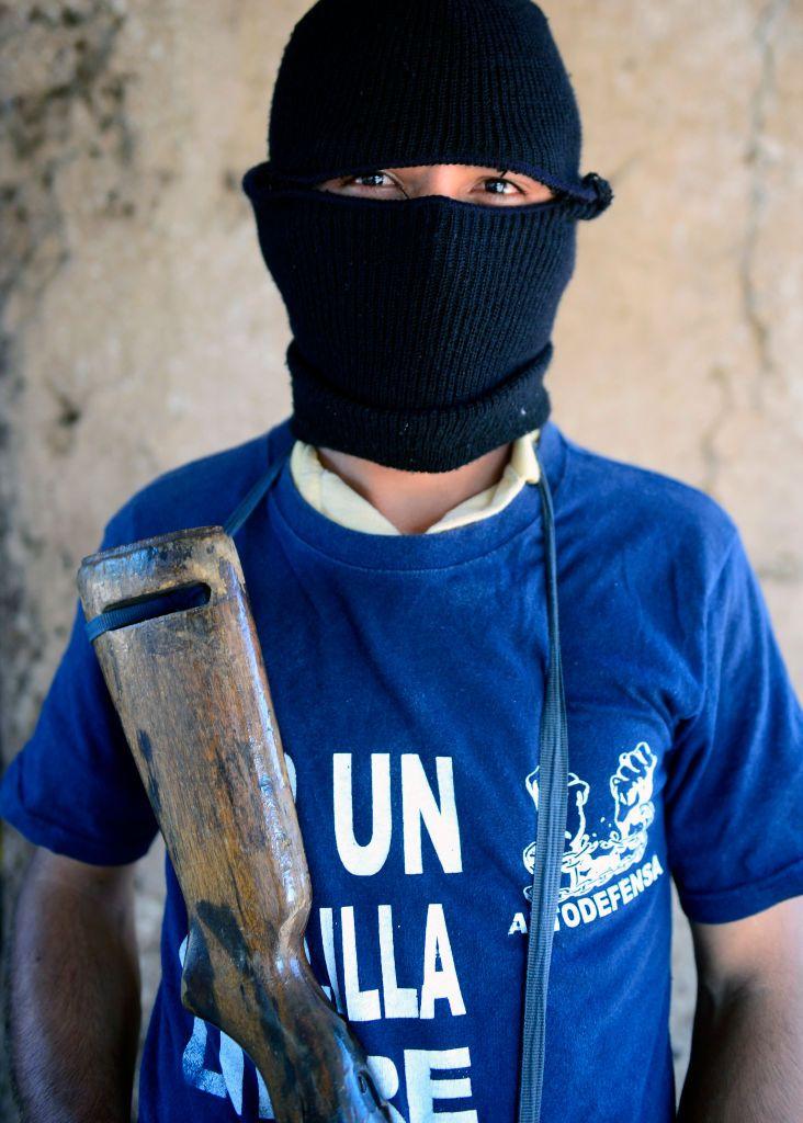 Un "informante" del grupo Los Caballeros Templarios con un arma y el rostro cubierto