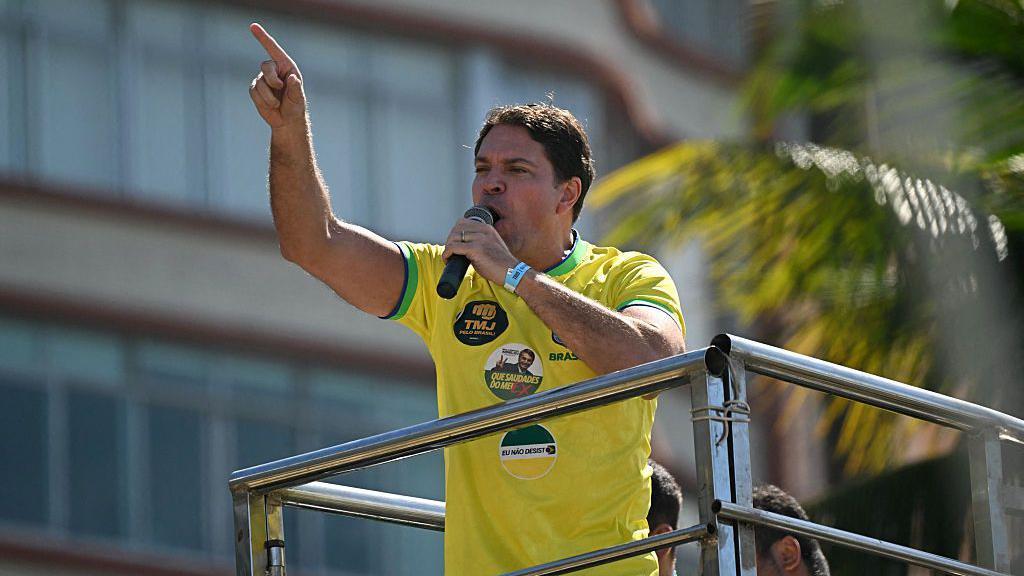 Alexandre Ramagem em um carro de som, vestido com uma camiseta amarela da Sele&ccedil;&atilde;o Brasileira de futebol, fazendo um discurso em um ato pr&oacute;-Bolsonaro no Rio de Janeiro em 2025. 