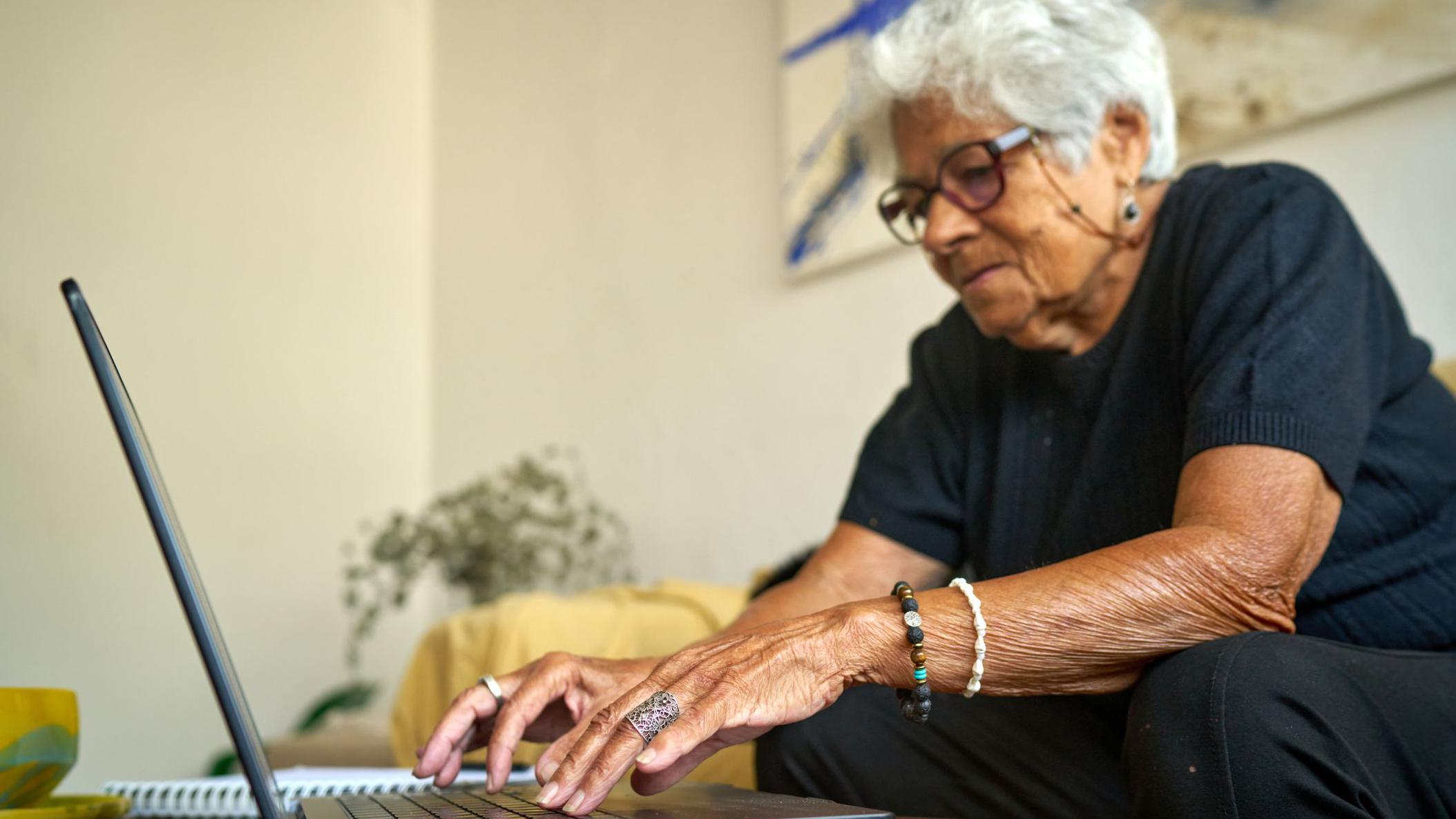 Mujer de edad avanzada con un computador.
