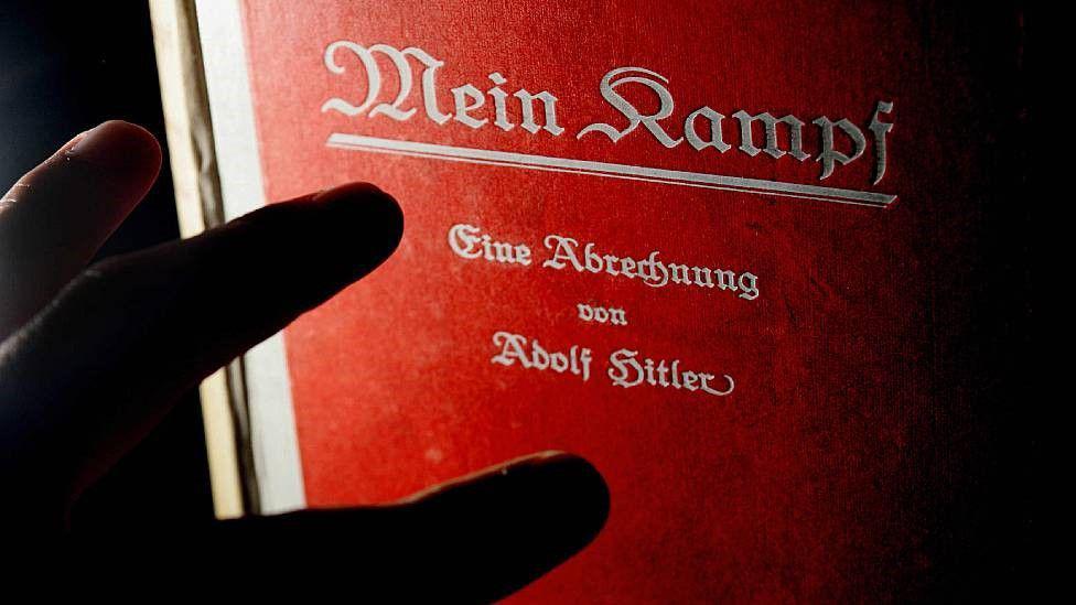 Una persona leyendo una copia original autografiada de Mein Kampf