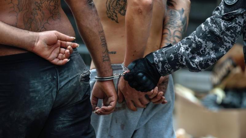 Primer plano de presos con las muñecas esposadas
