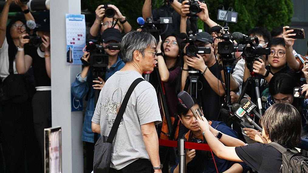 一名宏福苑居民到位於中環展城館聽證會現場，接受在場多間傳媒訪問。