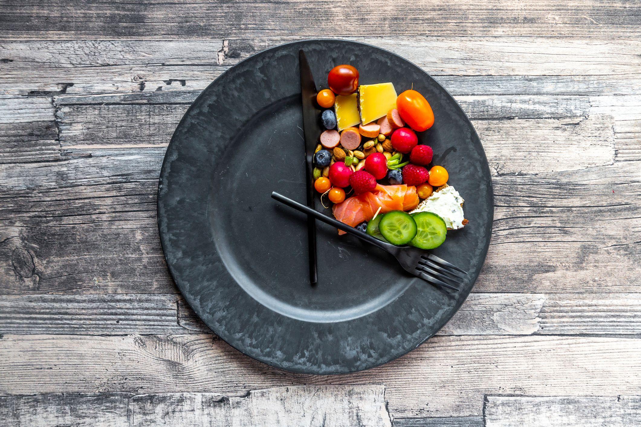 Un plato con algo de comida y los cubiertos colocados como si fueran las agujas del reloj.
