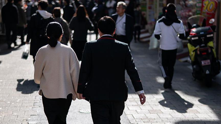 2026年2月6日，一對情侶在日本東京的一條商業街上散步。