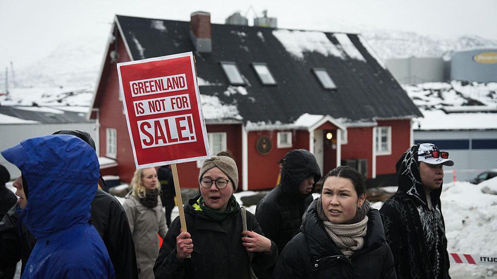 Pessoas com cartazes e bandeiras da Groenl&acirc;ndia se re&uacute;nem perto do Consulado dos Estados Unidos na capital groenlandesa, Nuuk, para protestar