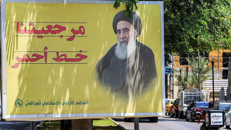 صورة للسيد علي السيستاني المرجع العراقي باللون الأصفر مع عبارة "مرجعيتنا خط أحمر" باللون الأحمر وتوقيع "المجلس الأعلى الإسلامي العراقي باللون الأخضر