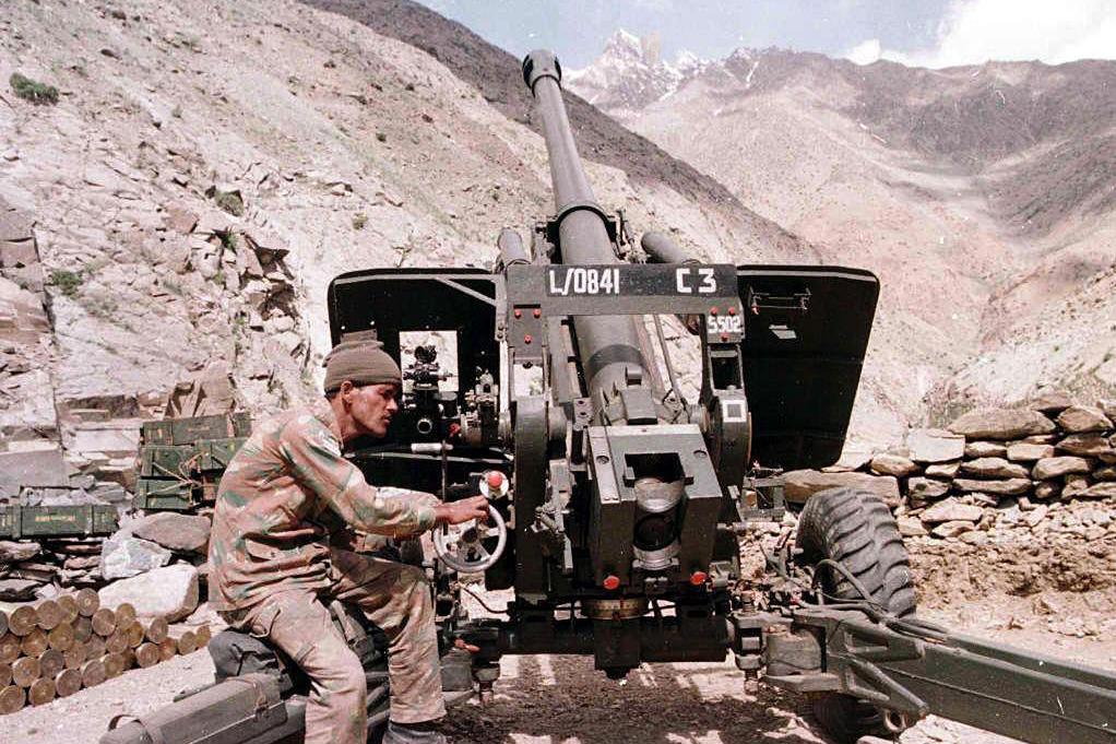 26 مئی 1999 کو کشمیر کے گاؤں دراس میں ایک انڈین فوجی ایک ہدف پر گولی چلانے کے لیے توپ کو سیدھا کر رہا ہے (فائل فوٹو)