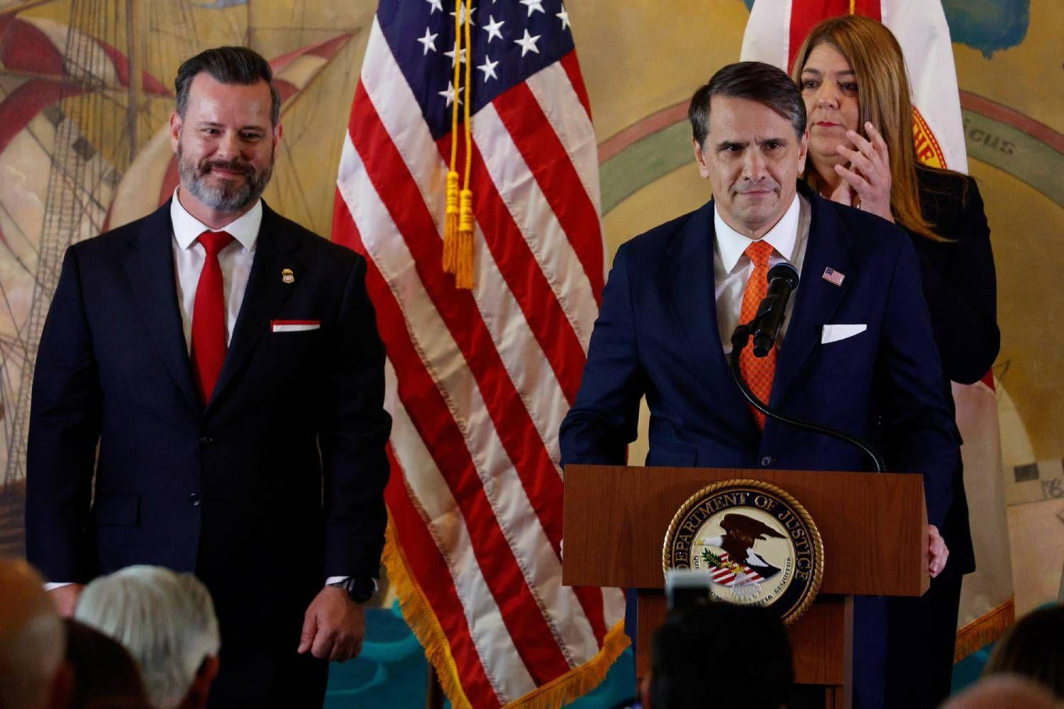 El fiscal general interino, Todd Blanche, habla desde un podio acompañado por el fiscal federal para el Distrito Sur de Florida, Jason A. Reding Quinones, y la presidenta de Miami Dade College, Madeline Pumariega.