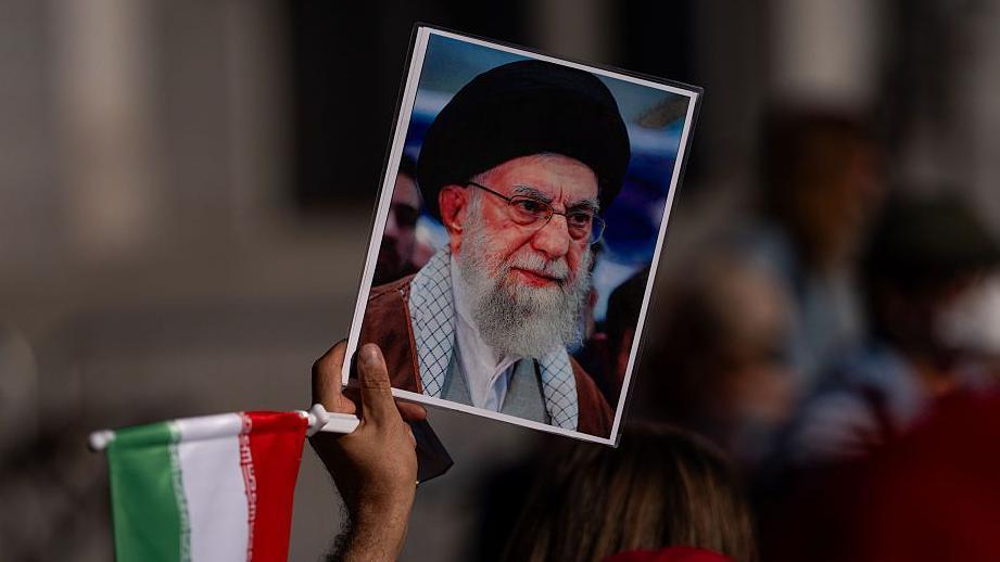 Un manifestante con un retrato del líder supremo de Irán, el ayatolá Alí Jamenei, protesta en Los Ángeles, California. 