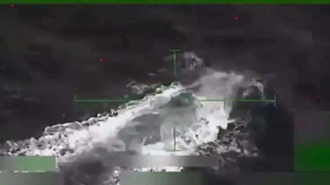 Imagen difuminada en blanco y negro en la que se percibe una especie de submarino que empieza a reflotar en el mar.