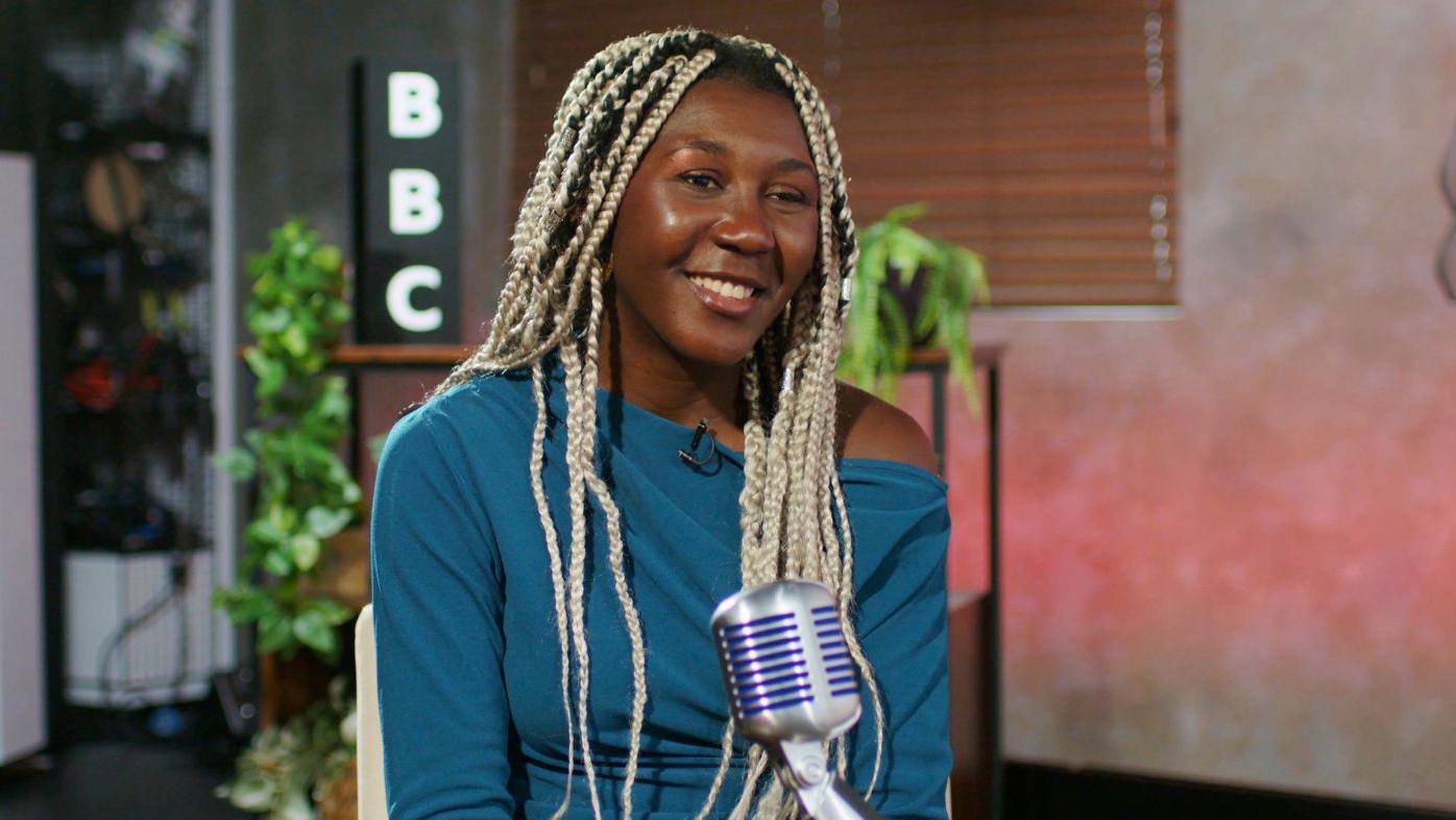 Yudi Heredia en su entrevista en la BBC en los estudios de Londres. Sentada, con un micrófono delante y plantas y una lámpara detrás. 
