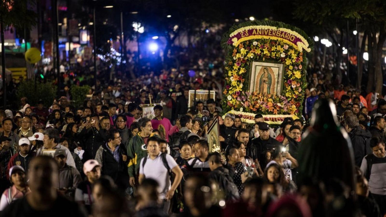 Una multitudinaria procesión nocturna de conmemoración en México, con unos devotos cargando la imagen de la Virgen de Guadalupe 