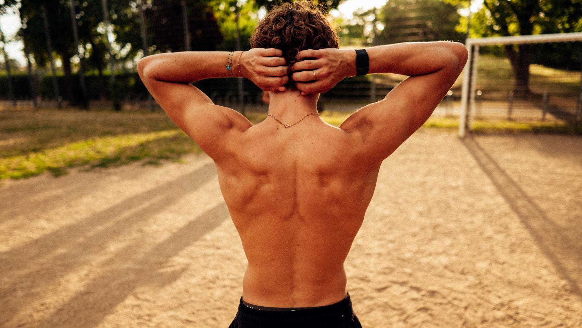 Un joven con espalda musculosa posa ante las cámaras. 